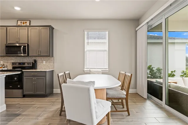 a kitchen with stainless steel appliances granite countertop a stove a sink a microwave a dining table and chairs