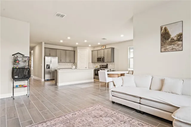 a living room with stainless steel appliances kitchen island granite countertop furniture and view of kitchen