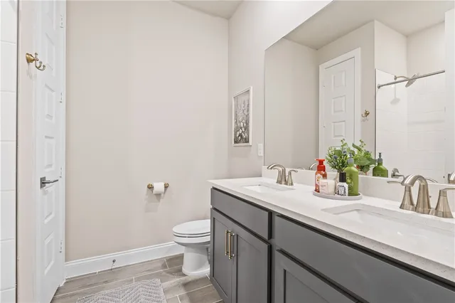 a bathroom with a granite countertop sink a toilet and a mirror