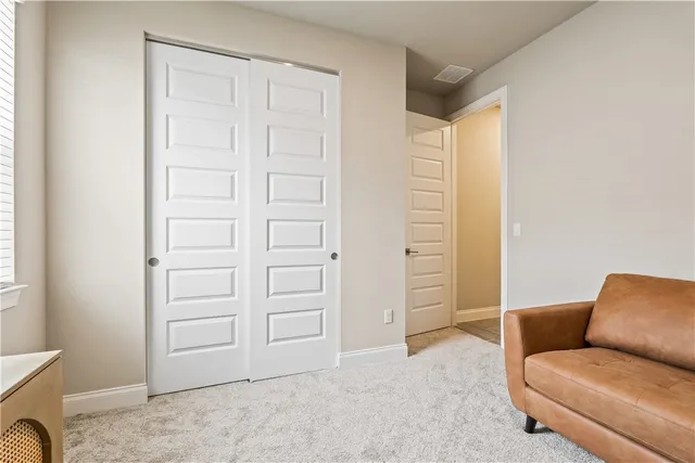 a view of a hallway with wooden floor and a bathroom