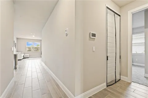an entryway with wooden floor and a mirror