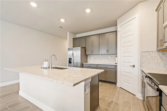 a kitchen with a sink a stove a refrigerator and white cabinets