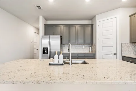 a kitchen with a refrigerator sink and cabinets