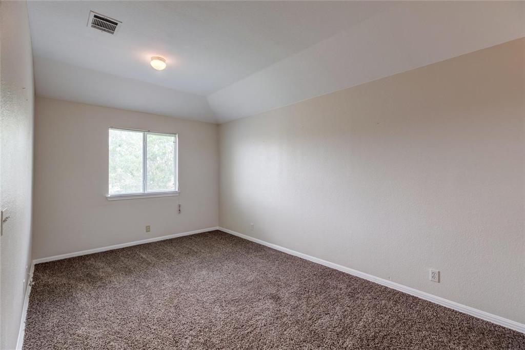 16712 Hamilton Point Circle Manor, TX 78653 - Photo 14 of 38 Soft carpeting pairs with a tray ceiling to create a welcoming and cozy bedroom atmosphere.