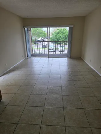 a view of a livingroom with a floor to ceiling window and an entryway