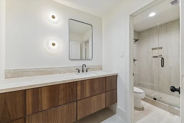 a bathroom with a sink a toilet and shower