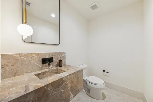 a bathroom with a sink a toilet and mirror