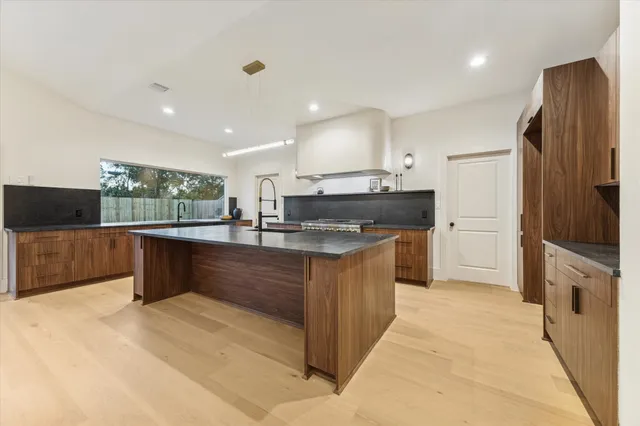 a large kitchen with stainless steel appliances kitchen island granite countertop a large counter top and a stove