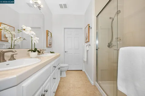 a en suite bathroom with a double vanity sink a large mirror and a bathtub