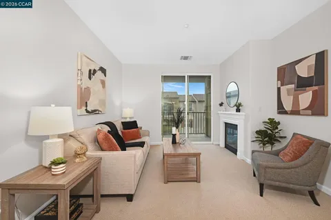 a living room with furniture a fireplace and a potted plant