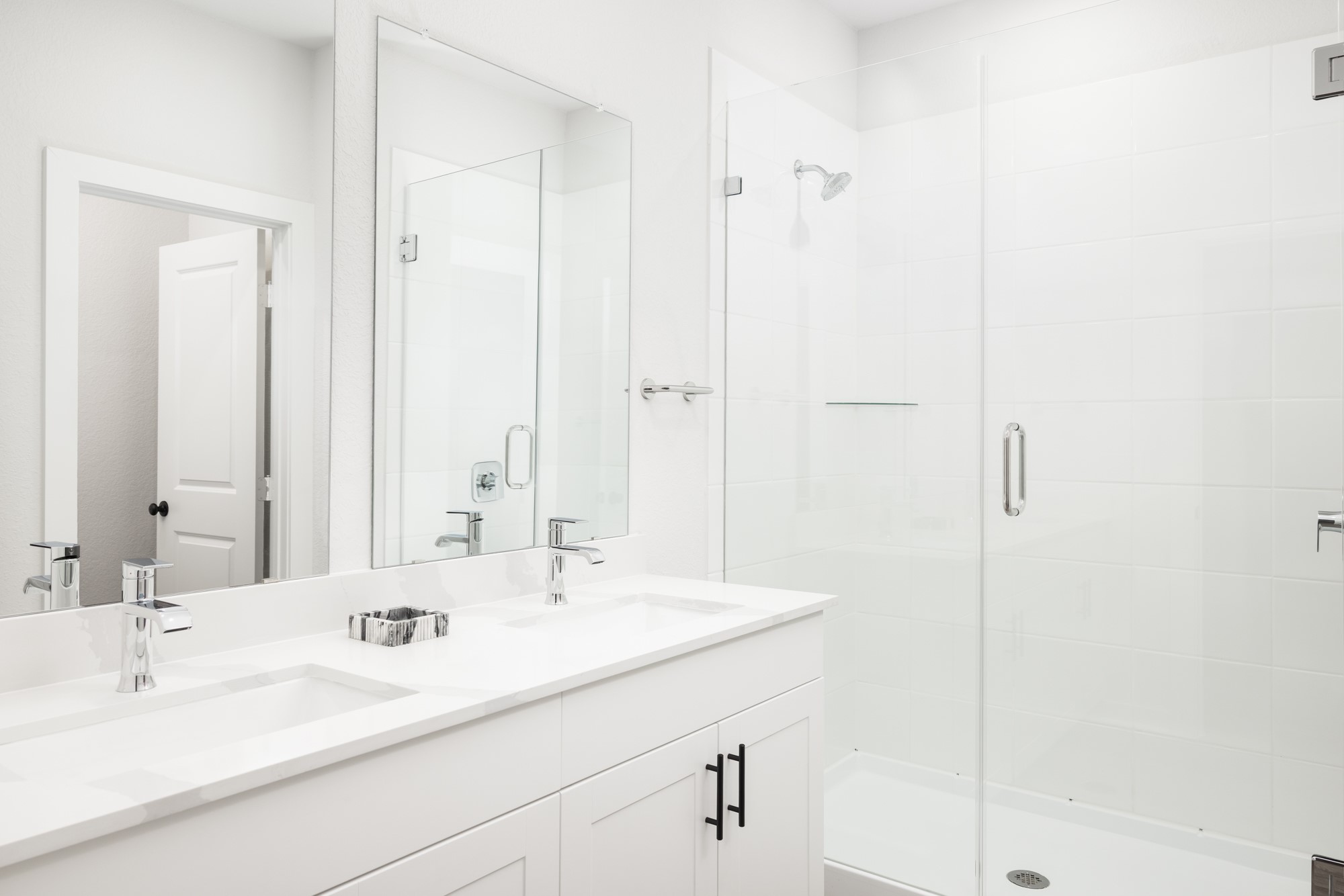 8107 Wilder Road Austin, TX 78736 - Photo 12 of 35 A well-appointed primary bathroom featuring a spacious dual vanity and a walk-in shower with clear glass enclosure.