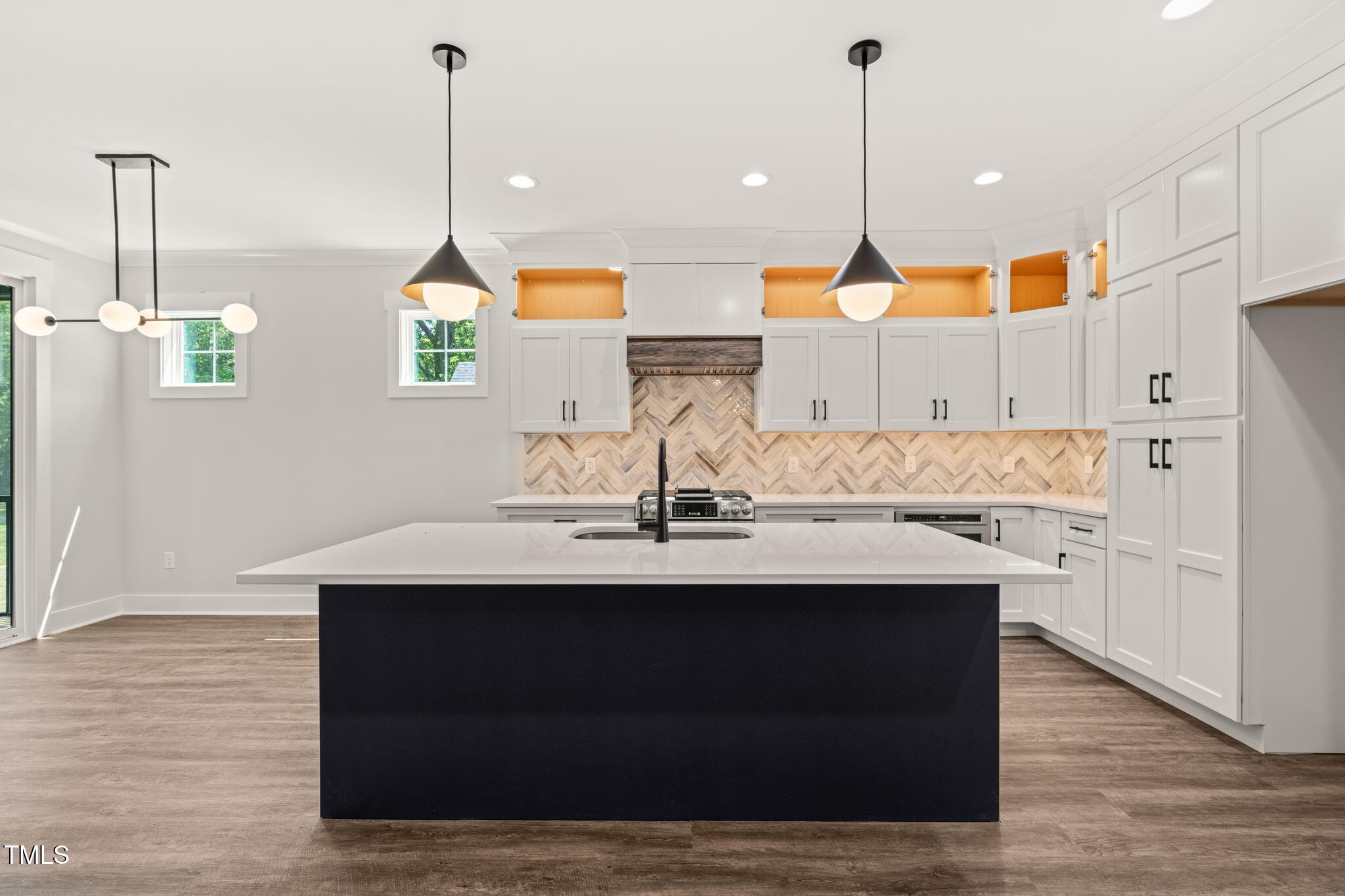 320 Pilot Ridge Road Zebulon, NC 27597 - Photo 7 of 49 a kitchen with kitchen island granite countertop a sink cabinets and wooden floor