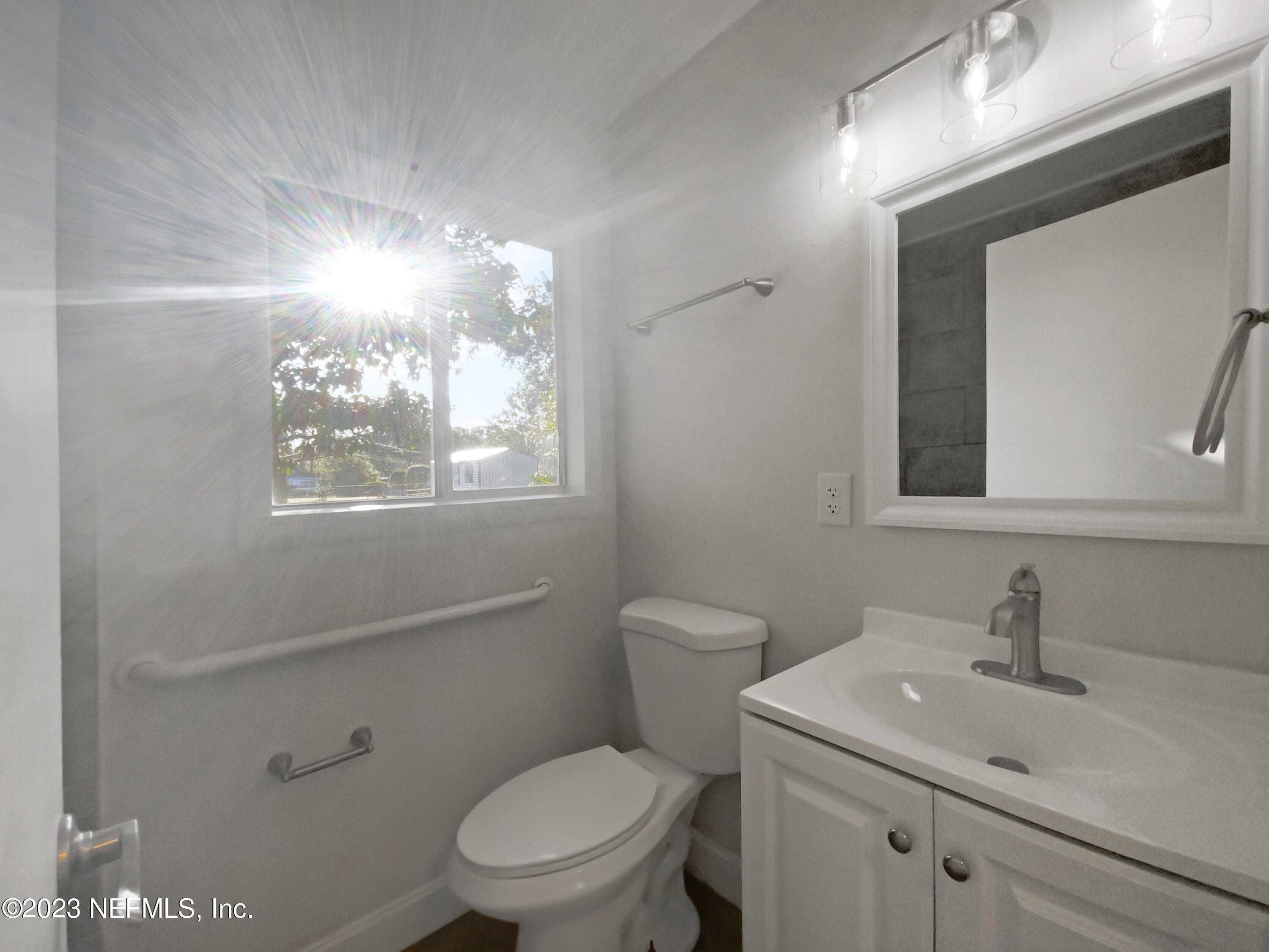 4204 Clyde Drive Jacksonville, FL 32208 - Photo 17 of 20 a bathroom with a toilet sink vanity and mirror