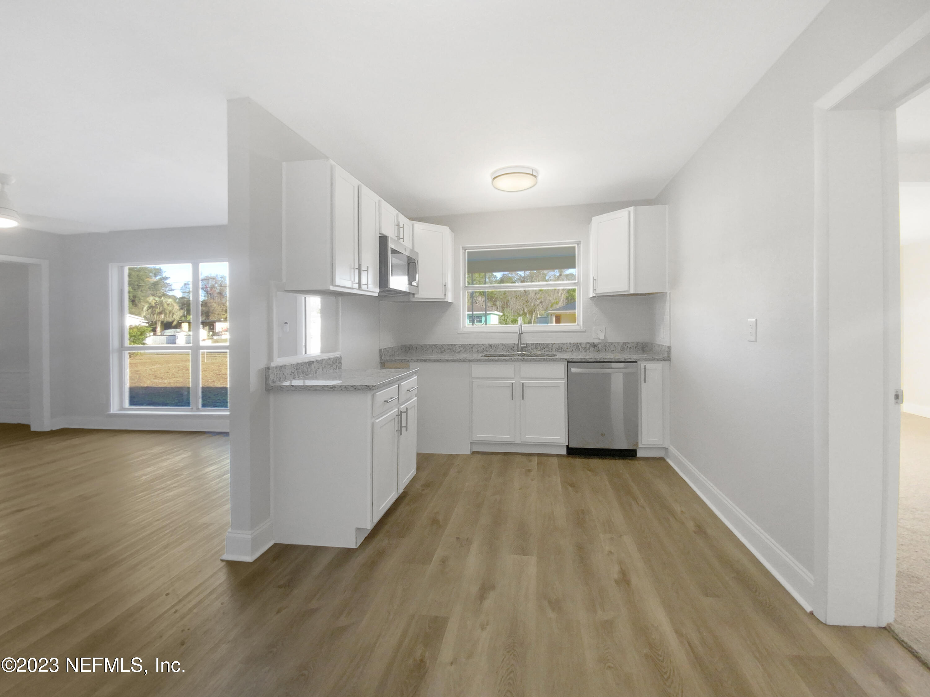 4204 Clyde Drive Jacksonville, FL 32208 - Photo 6 of 20 a kitchen with wooden floors and white appliances