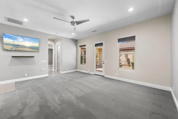 a view of swimming pool that has lawn chairs with plants and trees