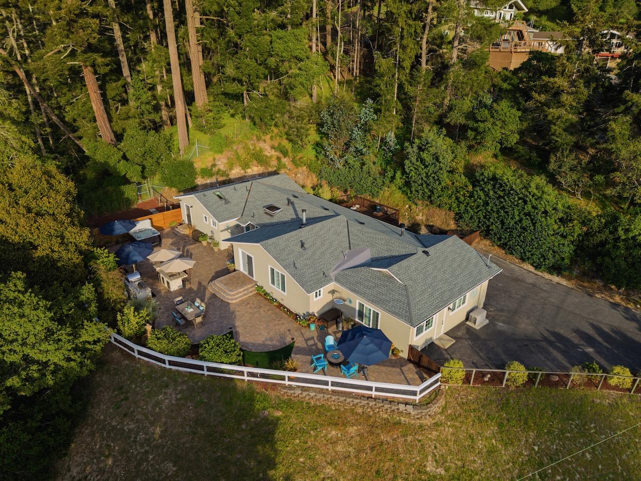 an aerial view of a house with swimming pool and outdoor seating