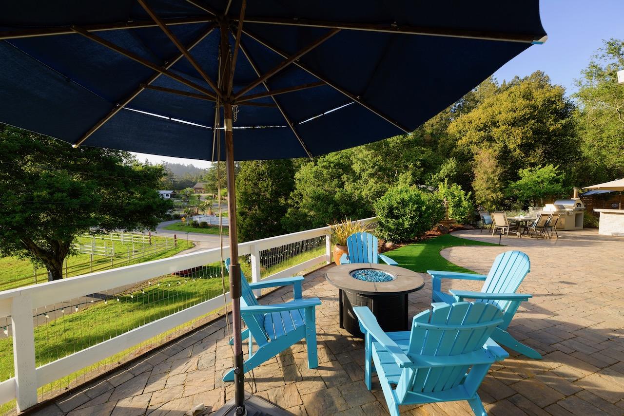 145 Rabbits Run Road Santa Cruz, CA 95060 - Photo 103 of 120 a patio with wooden floor a yard a table and chairs