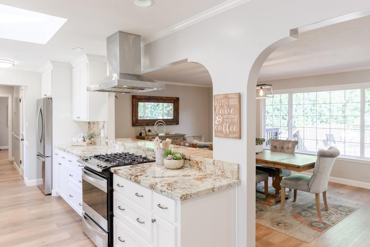 145 Rabbits Run Road Santa Cruz, CA 95060 - Photo 31 of 120 a kitchen with stainless steel appliances kitchen island granite countertop a stove a sink dishwasher and white cabinets with wooden floor