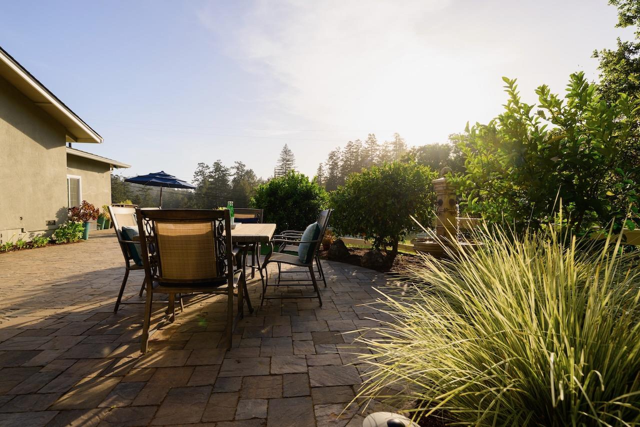 145 Rabbits Run Road Santa Cruz, CA 95060 - Photo 94 of 120 a view of a patio with table and chairs and potted plants with wooden floor and fence