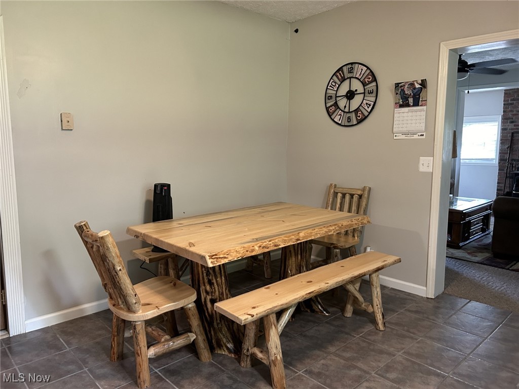 4853 Leon Road Andover, OH 44003 - Photo 9 of 33 Dining space with ceiling fan and dark tile patterned floors
