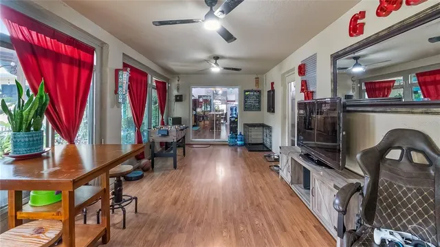 a living room with furniture a flat screen tv and a large window