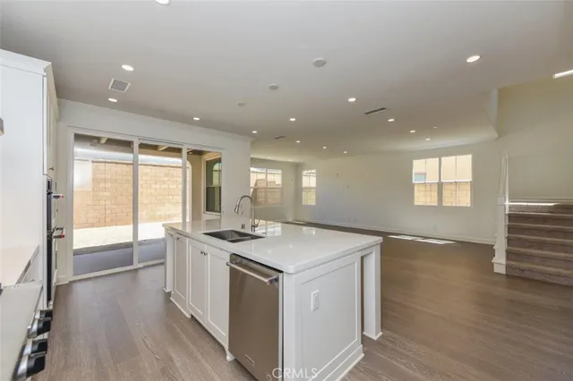 a kitchen that has a sink a stove and wooden floor