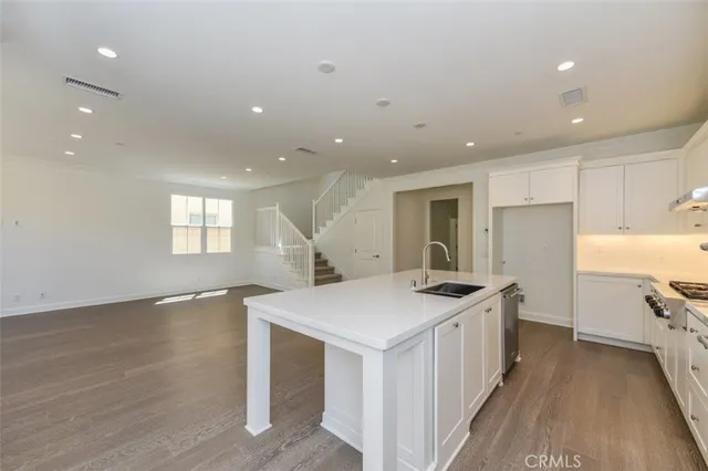 a kitchen with granite countertop a sink stove and refrigerator