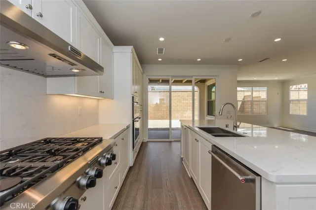 a kitchen with granite countertop a sink stove and cabinets