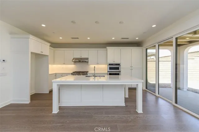 a open kitchen with stainless steel appliances granite countertop a sink stove and refrigerator