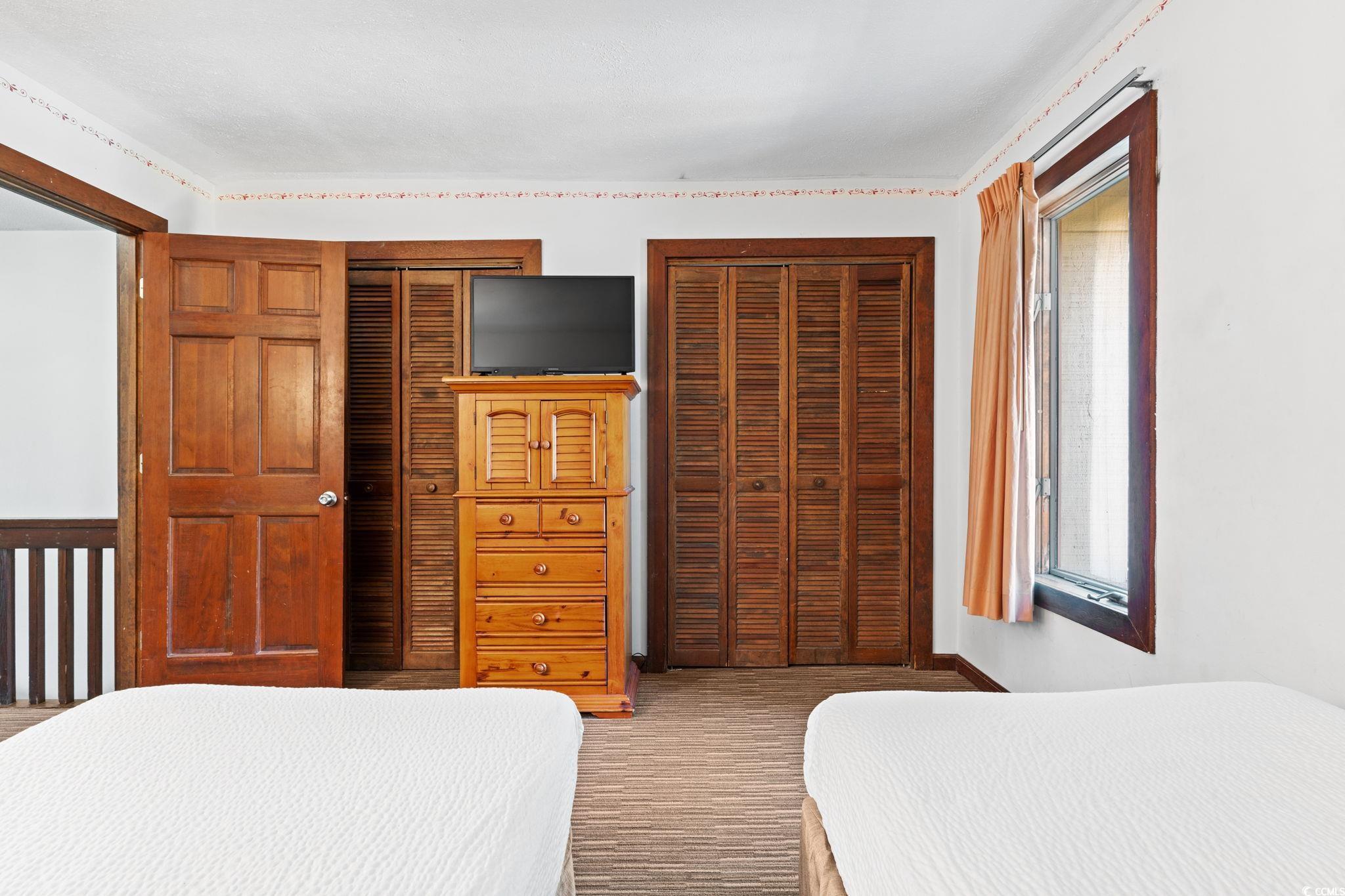 307 70th Avenue North, Unit 202 Myrtle Beach, SC 29572 - Photo 16 of 33 Bedroom with two closets and carpet