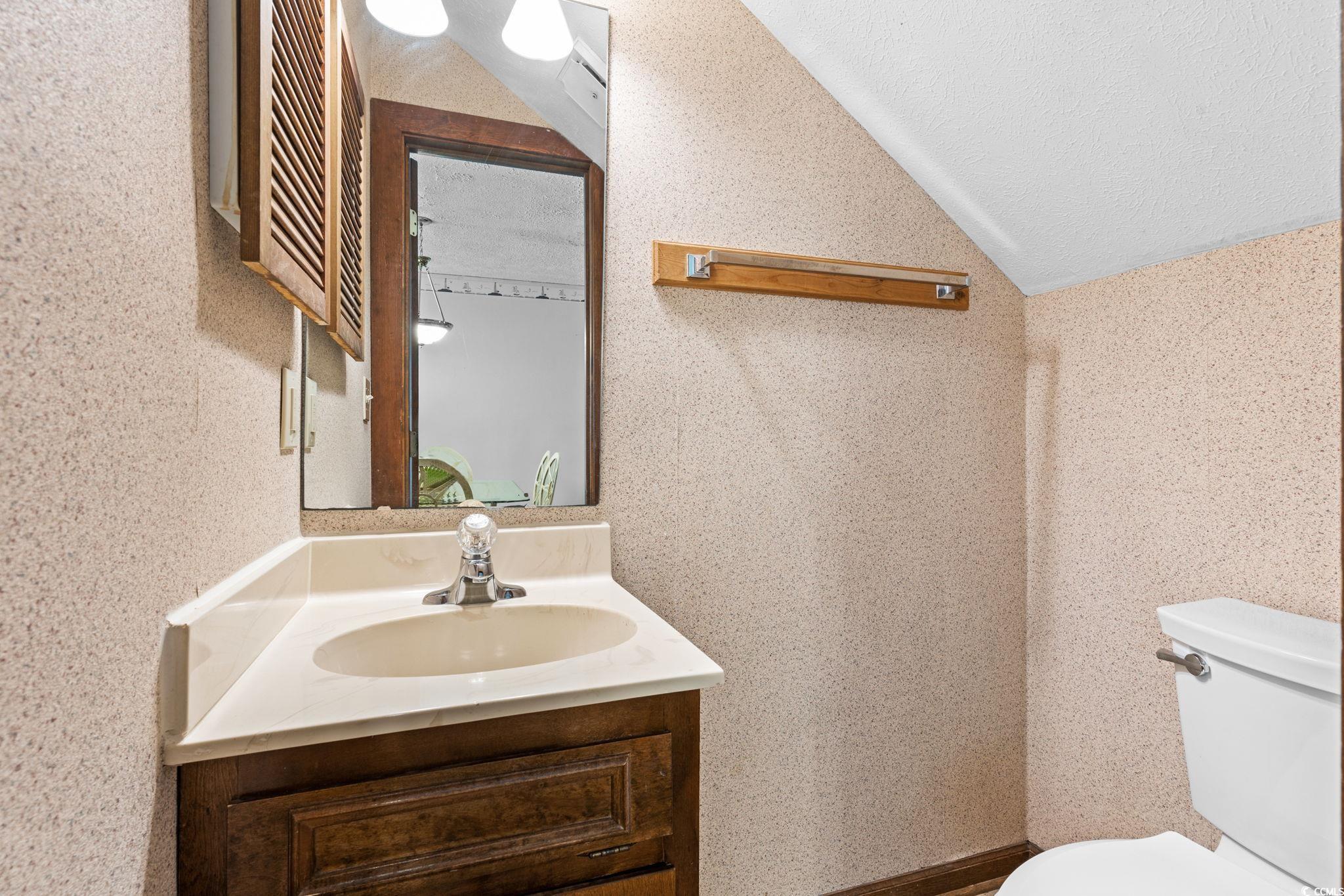 307 70th Avenue North, Unit 202 Myrtle Beach, SC 29572 - Photo 19 of 33 Bathroom with lofted ceiling, vanity, and a textured ceiling