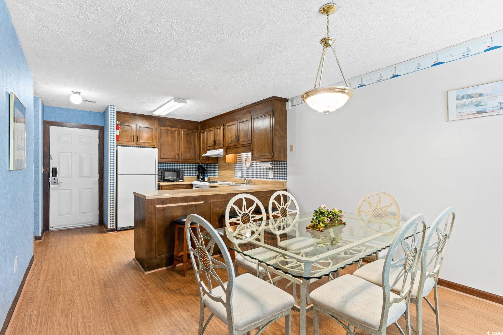 307 70th Avenue North, Unit 202 Myrtle Beach, SC 29572 - Photo 21 of 33 Dining space with a textured ceiling and light wood-type flooring