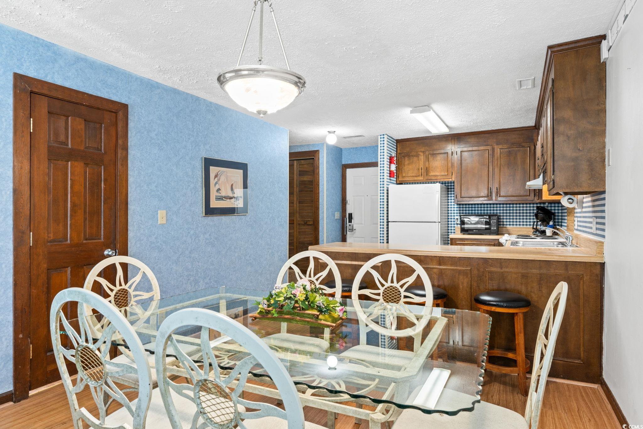 307 70th Avenue North, Unit 202 Myrtle Beach, SC 29572 - Photo 25 of 33 Dining space with light wood finished floors and a textured ceiling