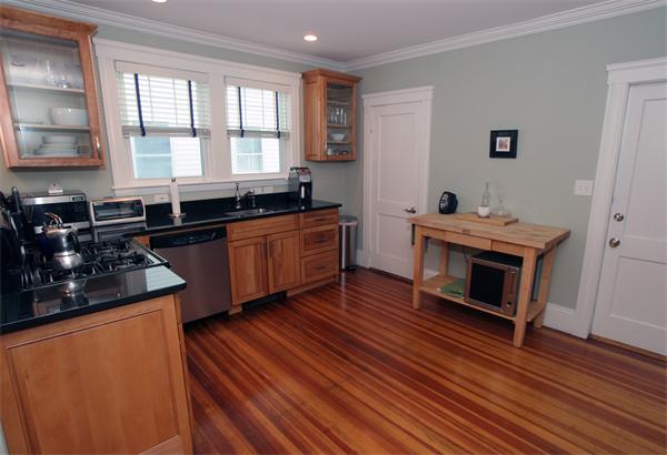 11 Roberts Road, Unit 2 Cambridge, MA 02138 - Photo 4 of 12 a kitchen with stainless steel appliances a stove a sink a refrigerator wooden floor and cabinets