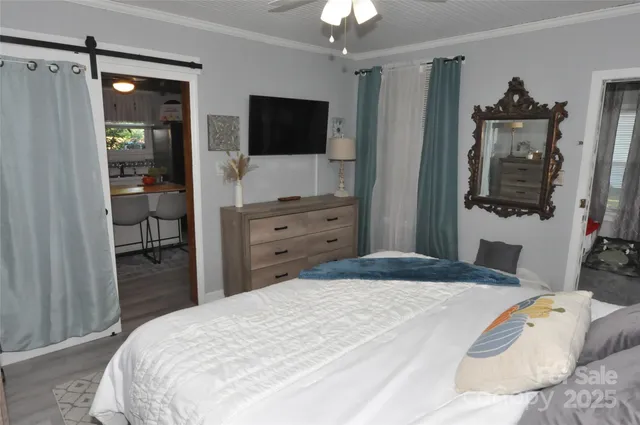 a bedroom with a bed and a flat tv screen on dresser