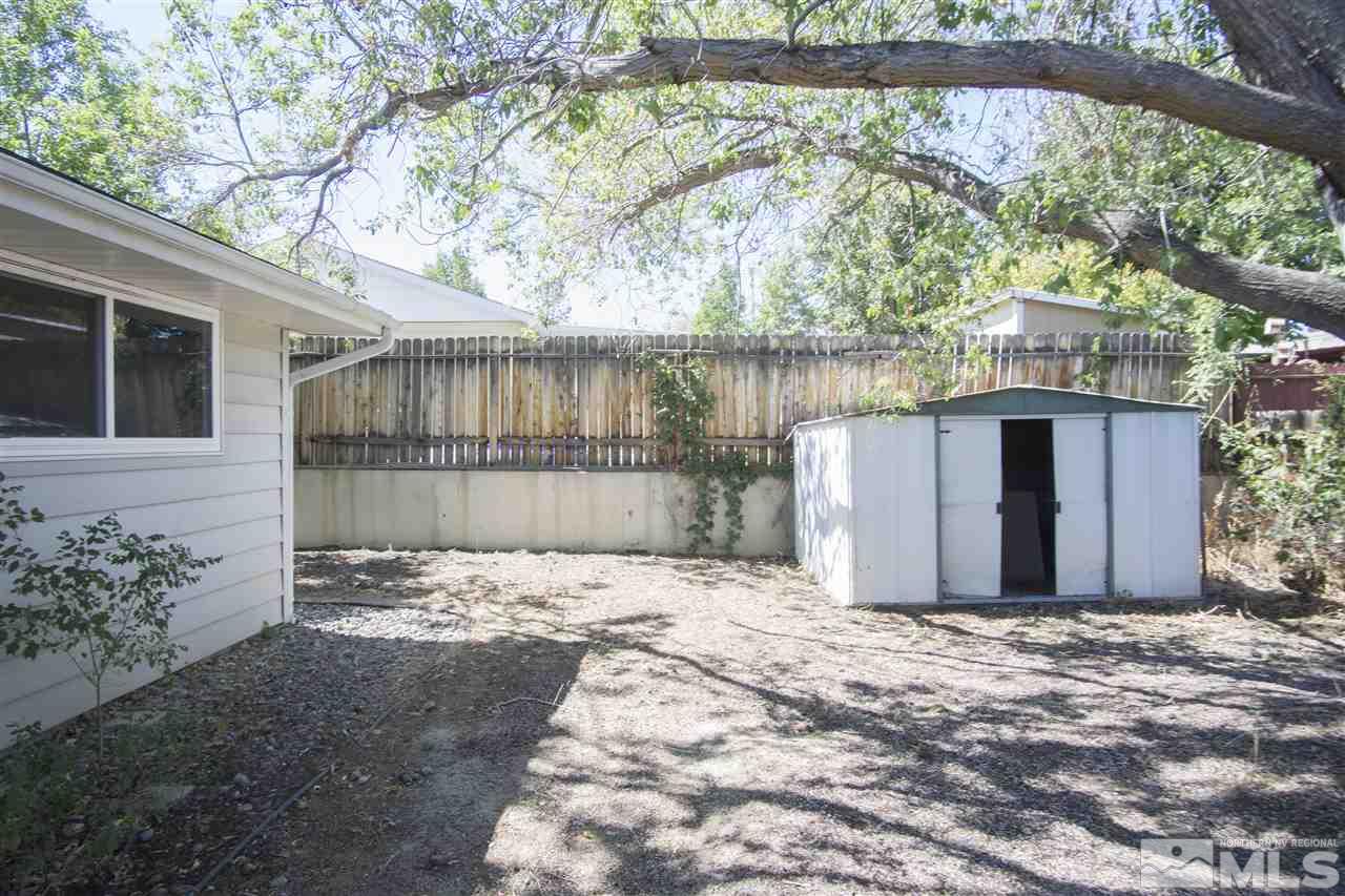 2245 West 6th Street Reno, NV 89503 - Photo 24 of 24 a view of backyard with large tree and wooden fence