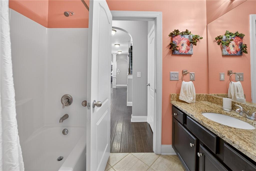 2300 Tucker Mill Road Southwest Conyers, GA 30094 - Photo 17 of 45 a bathroom with a granite countertop sink a mirror and shower