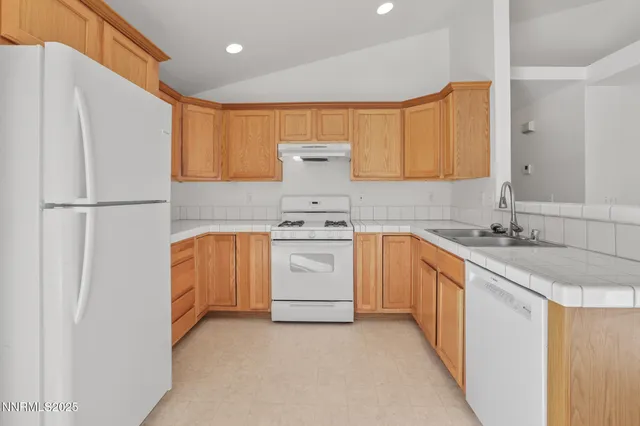 a kitchen with white cabinets and white appliances