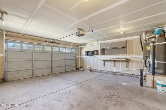 a view of a backyard with table and chairs plants and wooden fence
