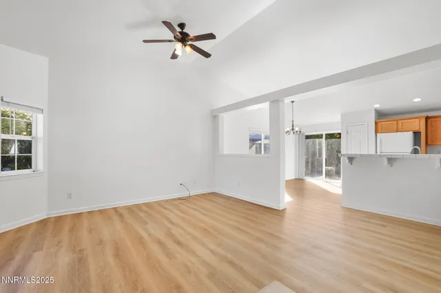 a view of empty room with wooden floor and ceiling fan