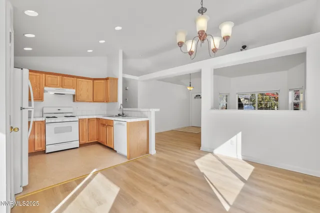 a large kitchen with stainless steel appliances a large counter top a sink a stove and a refrigerator