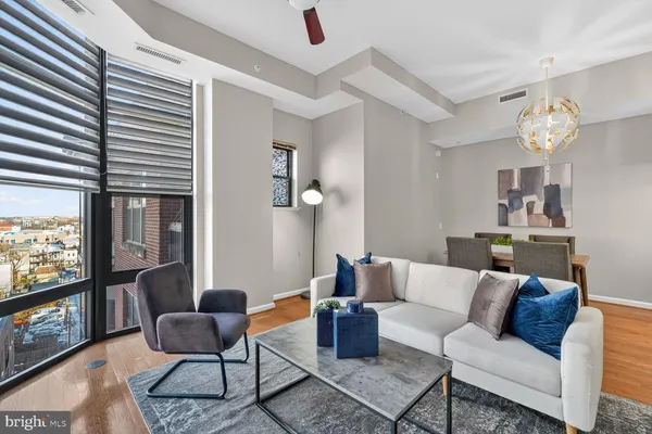 a living room with furniture a flat screen tv and a window