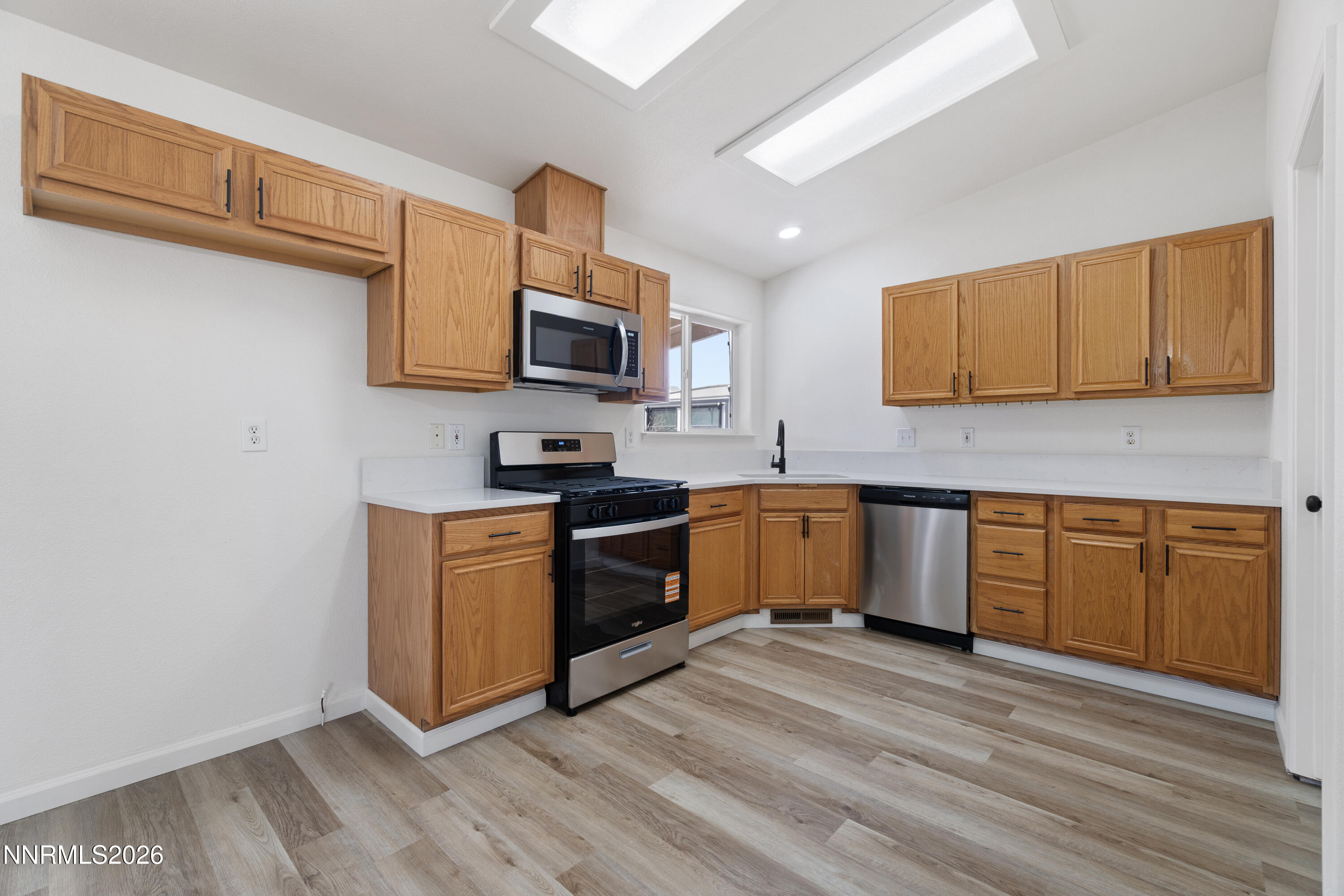 4015 Raven Drive Fallon, NV 89406 - Photo 11 of 29 a kitchen with granite countertop a stove top oven a sink dishwasher and a microwave oven with wooden floor