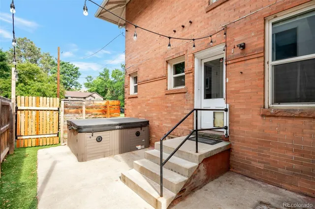 a backyard of a house with wooden fence and two chairs