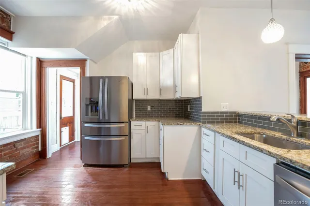 a kitchen with a refrigerator sink and cabinets