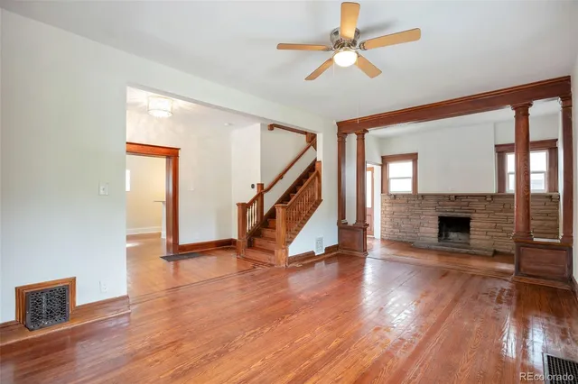 a view of a livingroom with wooden floor a fireplace and window