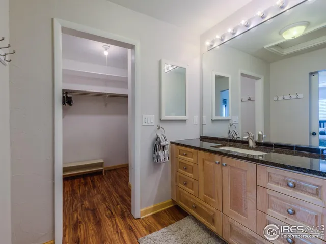 a spacious bathroom with a granite countertop sink and a mirror