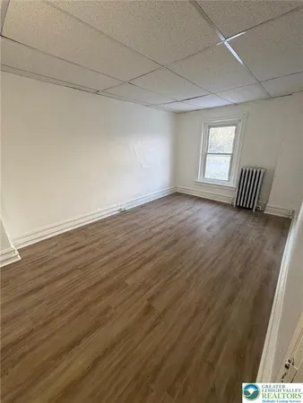 a view of a room with wooden floor and window