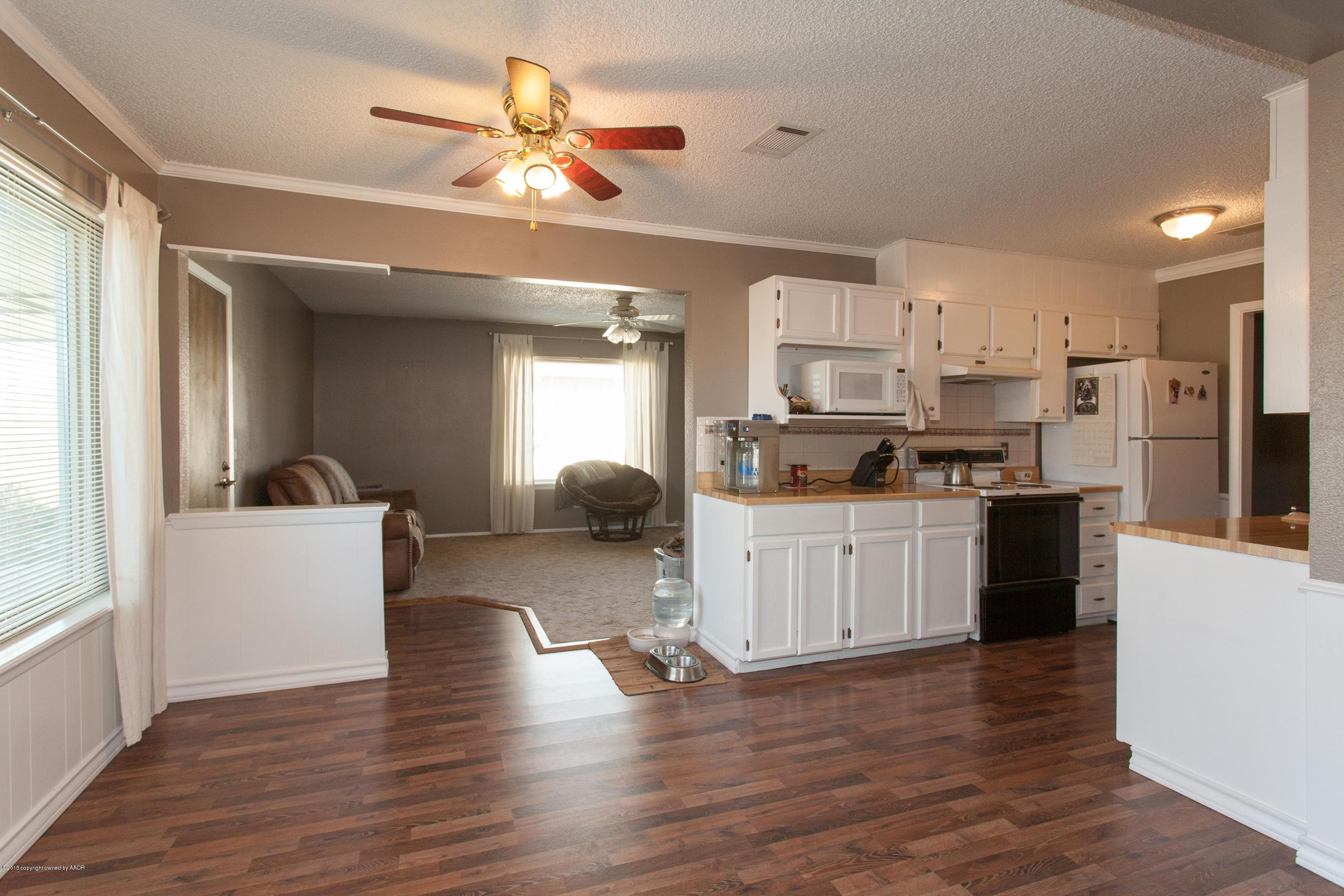 2418 Southwest 49th Avenue Amarillo, TX 79110 - Photo 6 of 30 a kitchen with kitchen island white cabinets and refrigerator