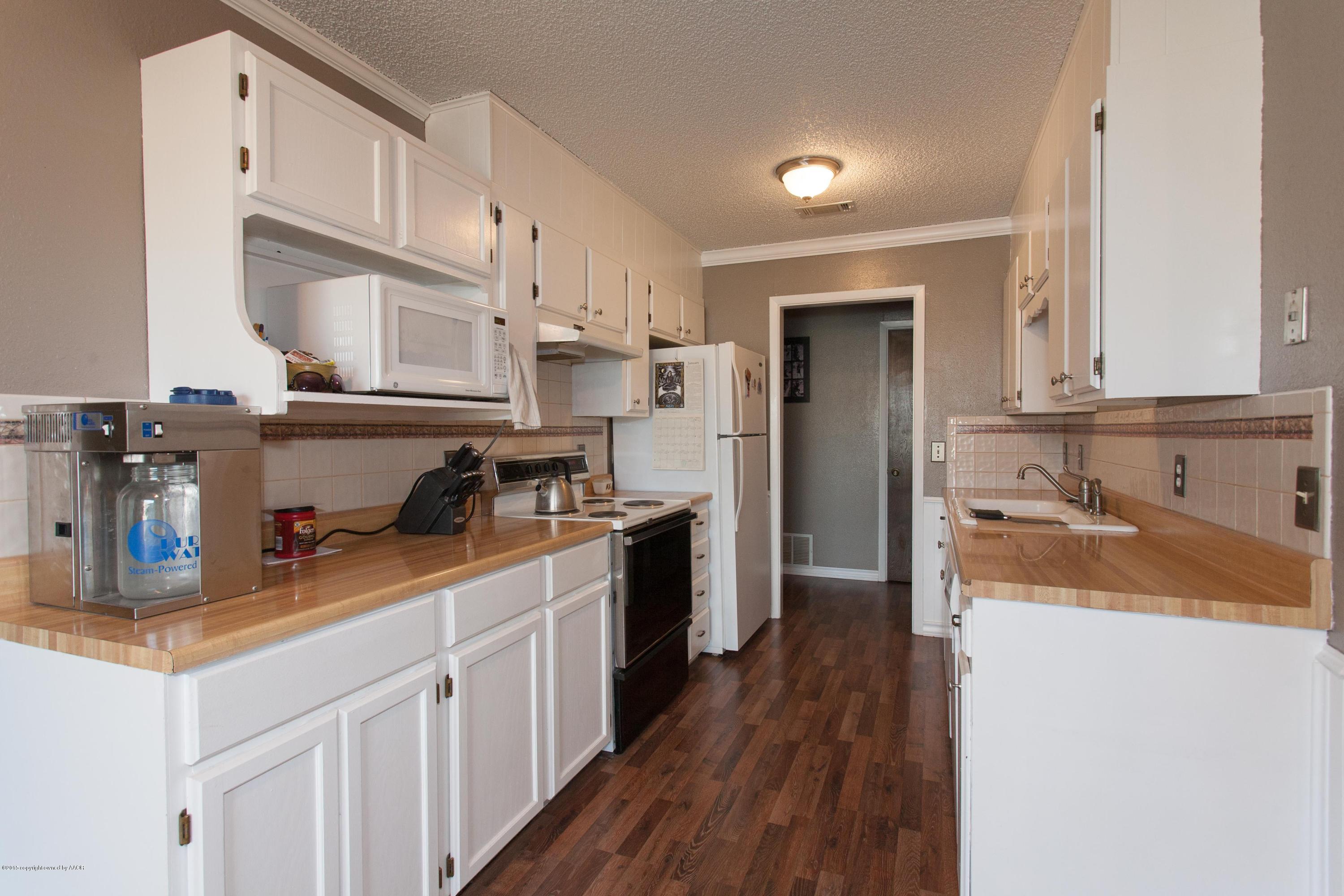 2418 Southwest 49th Avenue Amarillo, TX 79110 - Photo 7 of 30 a kitchen with a sink a stove and cabinets